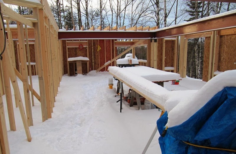 Wood framing in winter. The wood framing is covered in several inches of snow.