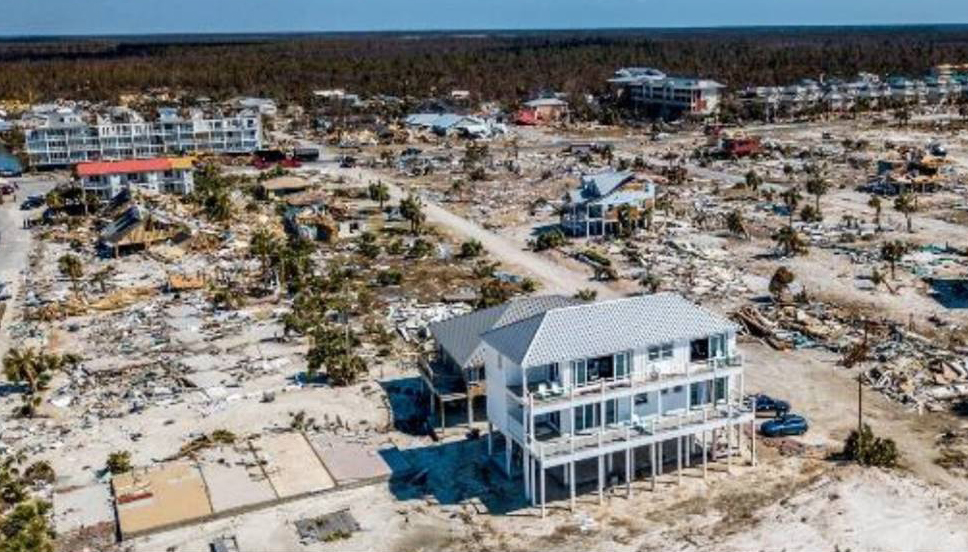 A single home standing amidst houses that have been destroyed by a hurricane. The singular house that is standing has been built using Nudura ICFs.