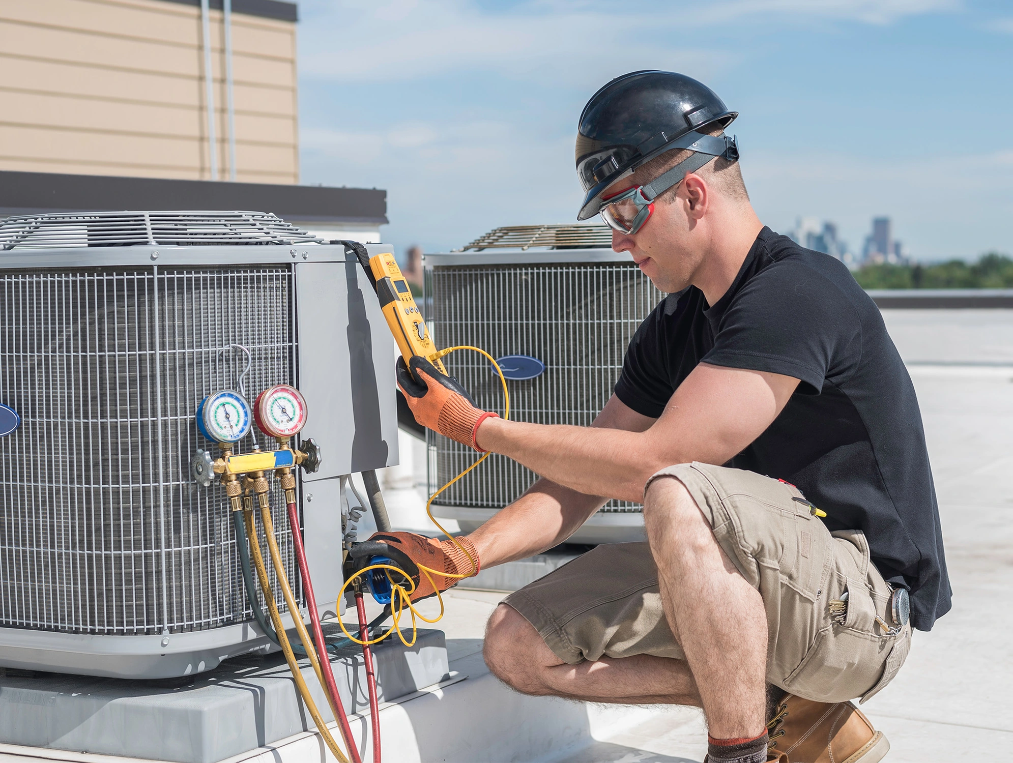 technician viewing hvac system on roof of building