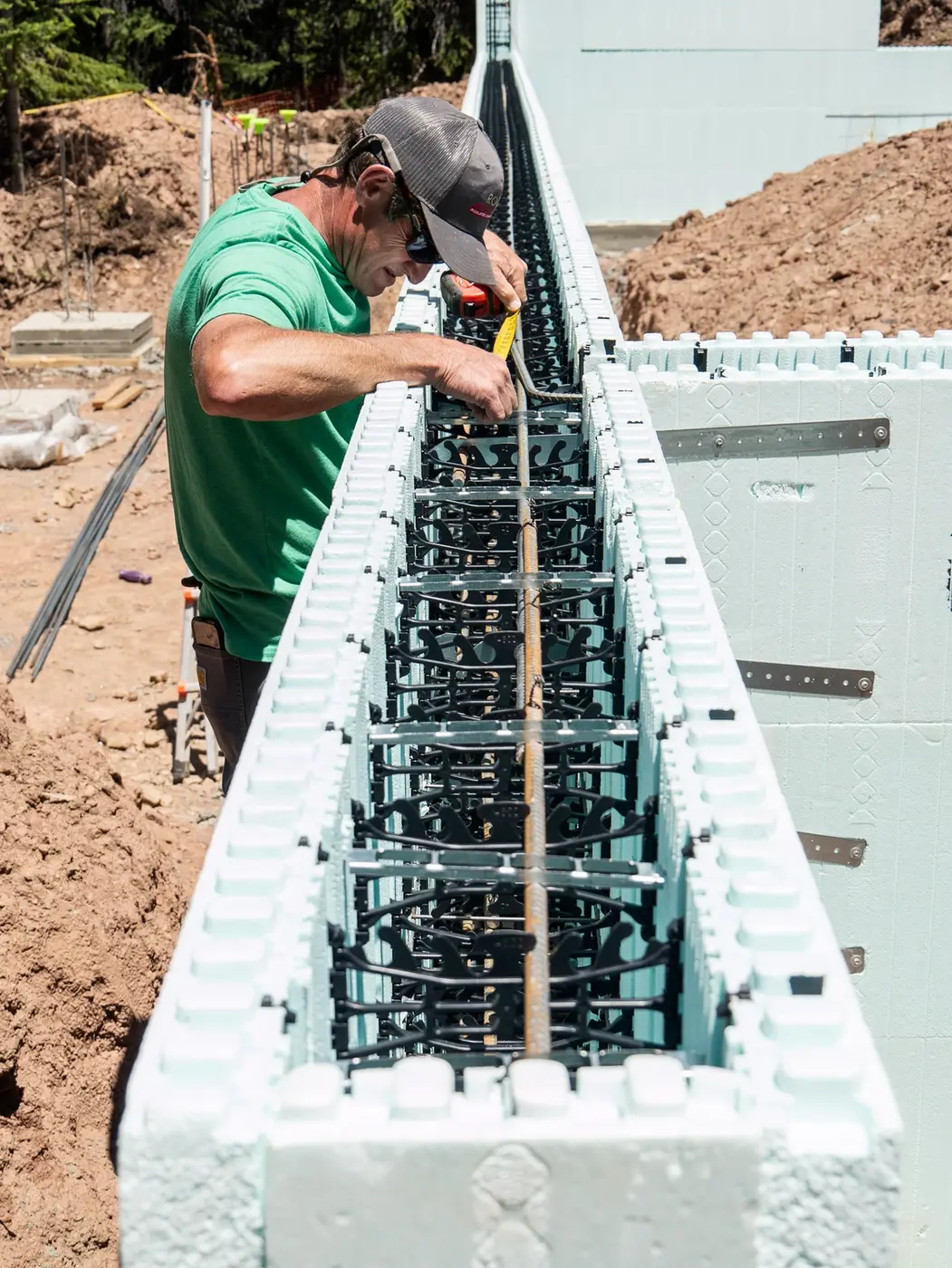worker installing rebar in icf wall